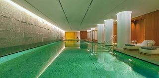 The Bulgari Spa London pool with large white columns and blue tiled pools