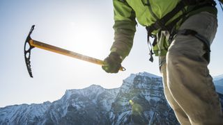 Close up of a mountaineer carrying an ice axe