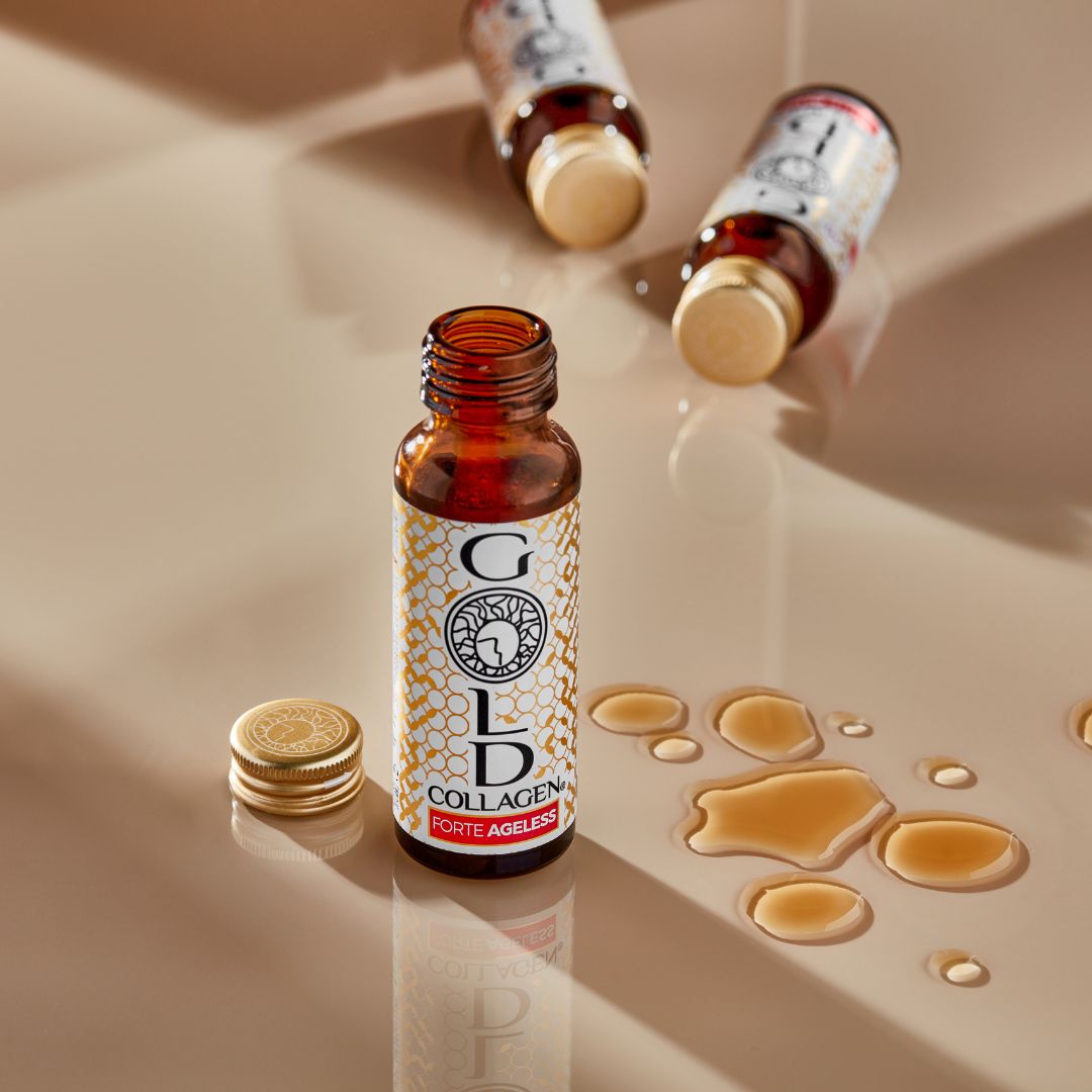 A bottle of gold Collagen Forte Ageless with drops of the liquid collagen beside it and the cao unscrewed