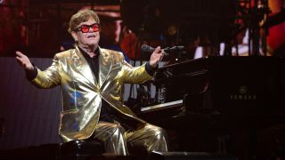 Elton John sits in front of his piano at Glastonbury