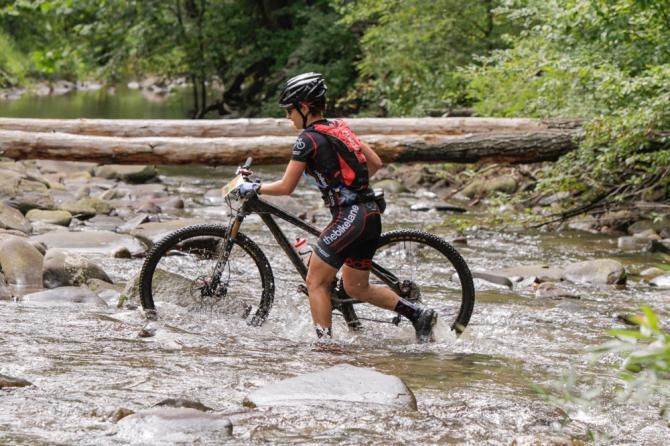 The harsh rain made the typically dry wash of Ramsey&rsquo;s Draft unrideable. Pictured, Karen Talley Mead (The Bike Lane) scrambles across.