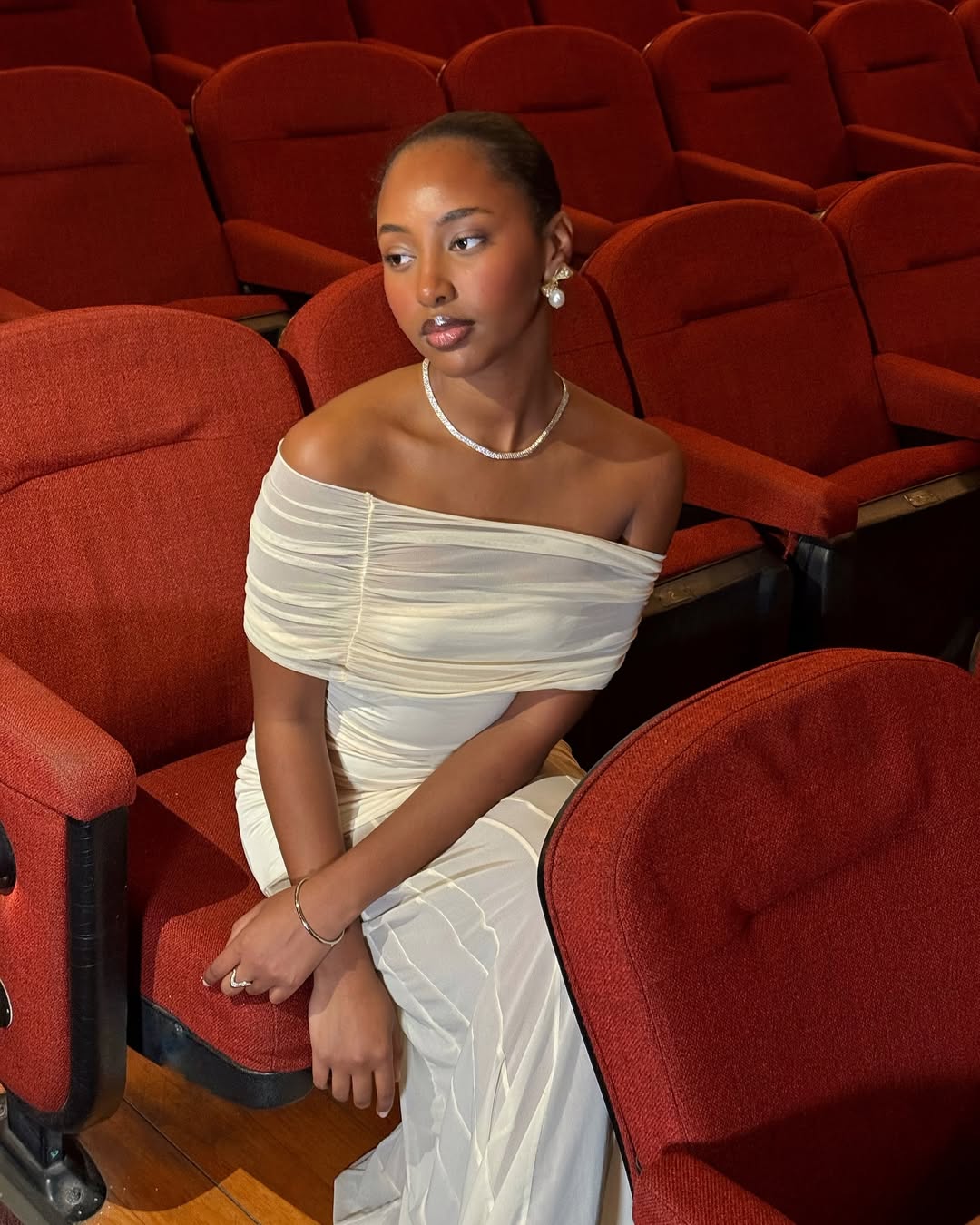 Rayan Xasan wears warm-toned makeup and a slick bun