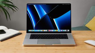 MacBook Pro 16 tum på ett träbord i ett modernt kontor