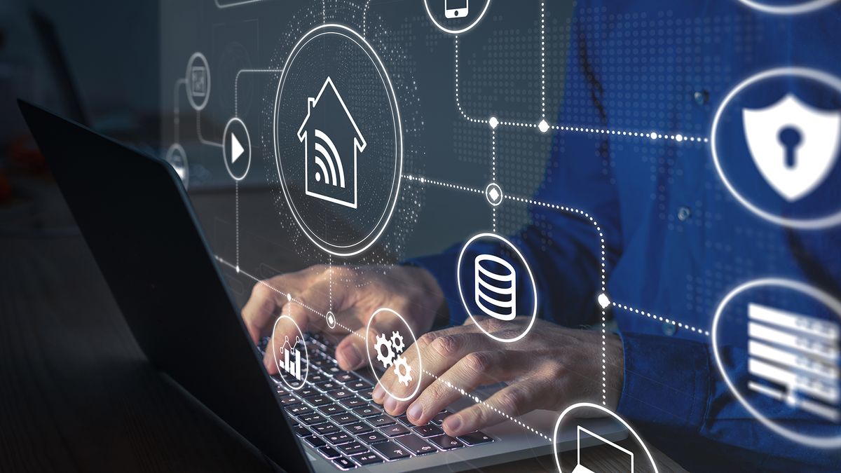 A man typing on a laptop keyboard with icons for home wifi, security, storage, analytics, settings and more floating around