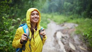 A woman wears a yellow raincoat on the trail