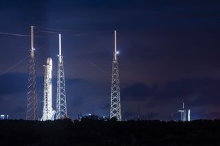 A SpaceX Falcon 9 rocket (left) carrying the GPS II SV04 navigation satellite for the U.S. military stands atop Space Launch Complex 40 at the Cape Canaveral Air Force Station in Florida. Another Falcon 9 carrying 60 Starlink internet satellites can be seen in the background at right at NASA's Pad 39A of the Kennedy Space Center.