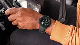 Man driving truck wearing Garmin Instinct 2 Dezl watch
