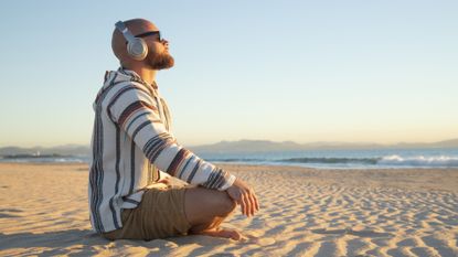Man sitting on a beach meditating