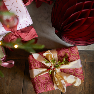 Decorating ideas. High angle close up of red paper bauble and wrapped Christmas presents.