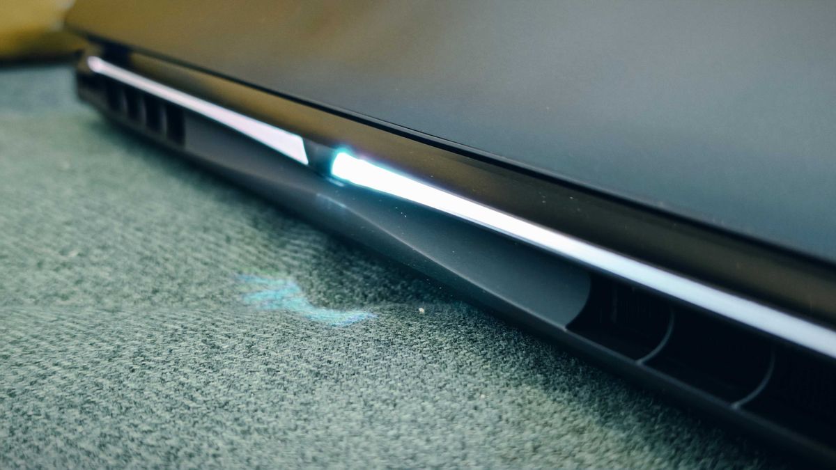 A Gigabyte Aorus Master 16 laptop on a green sofa