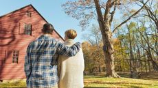 Rear view of couple facing cottage house