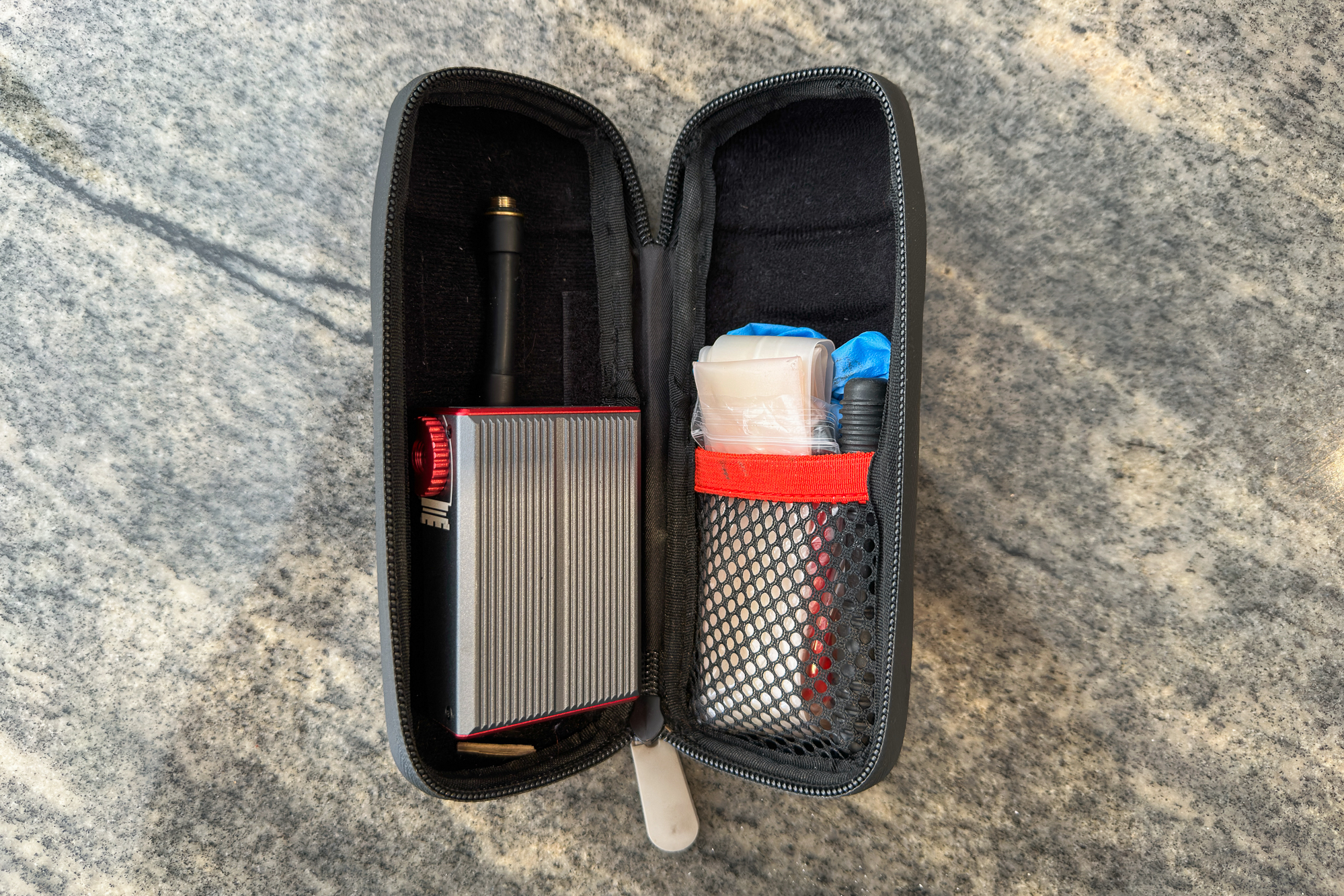 A Silca Elettrico Ultimate Inflator in a bottle cage tool tub with an inner tube