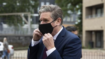 Keir Starmer wearing a black face mask.