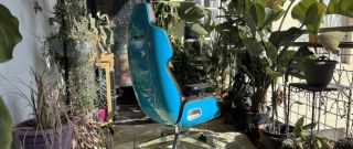 bright teal gaming chair on patio with plants