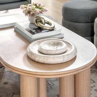 A light wood coffee table with decorative accessories on top