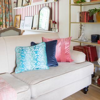 A living room with a cream sofa and multicoloured scatter cushions