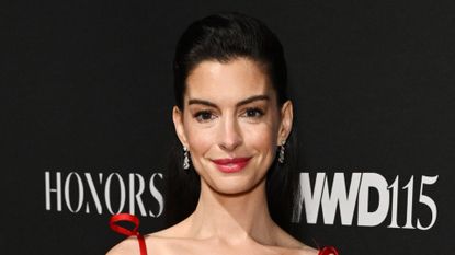 Anne Hathaway wearing red Valentino gown at the WWD Honors on October 28, 2025 in New York
