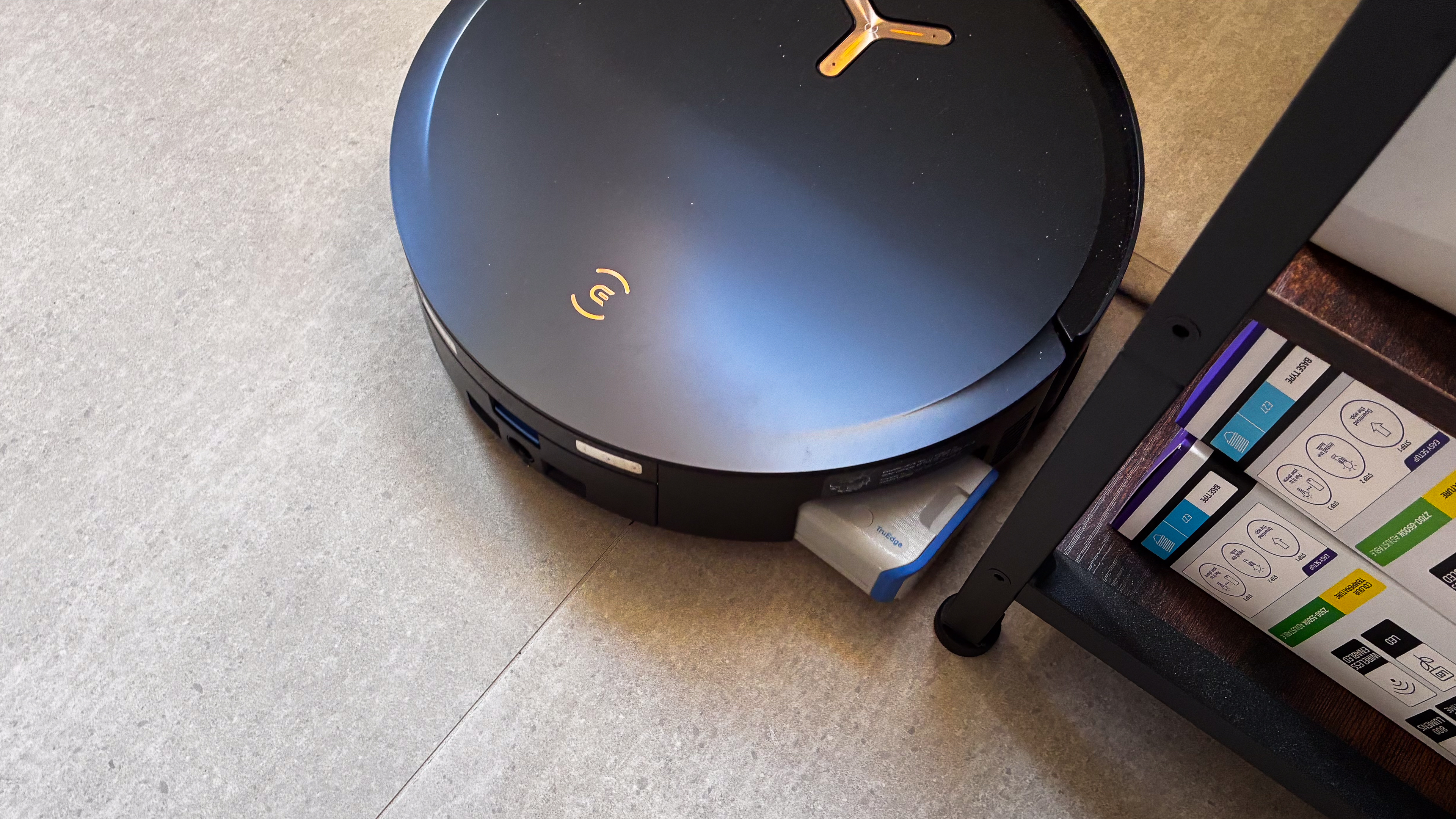 The wet roller extended against a tablet as the Ecovacs Deebot X8 Pro Omni mops