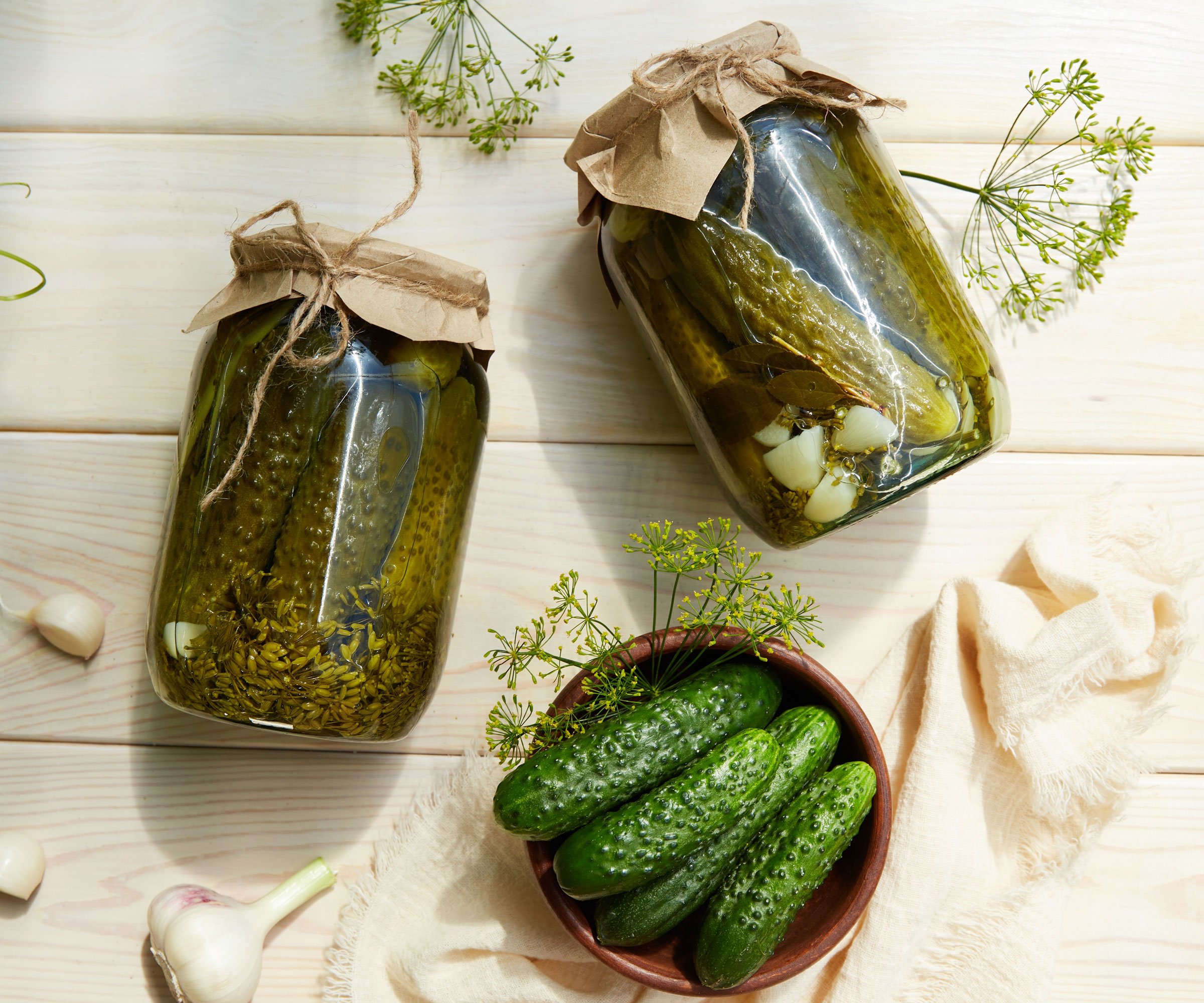 cucumbers in dish near glass jars of pickled cucumbers