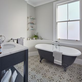 bathroom with white walls and printed tiled flooring
