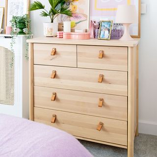 bedroom area with light wood chest of drawers