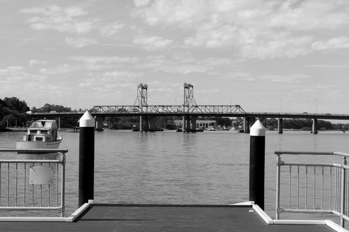 A black and white photo of a bridge and a jetty
