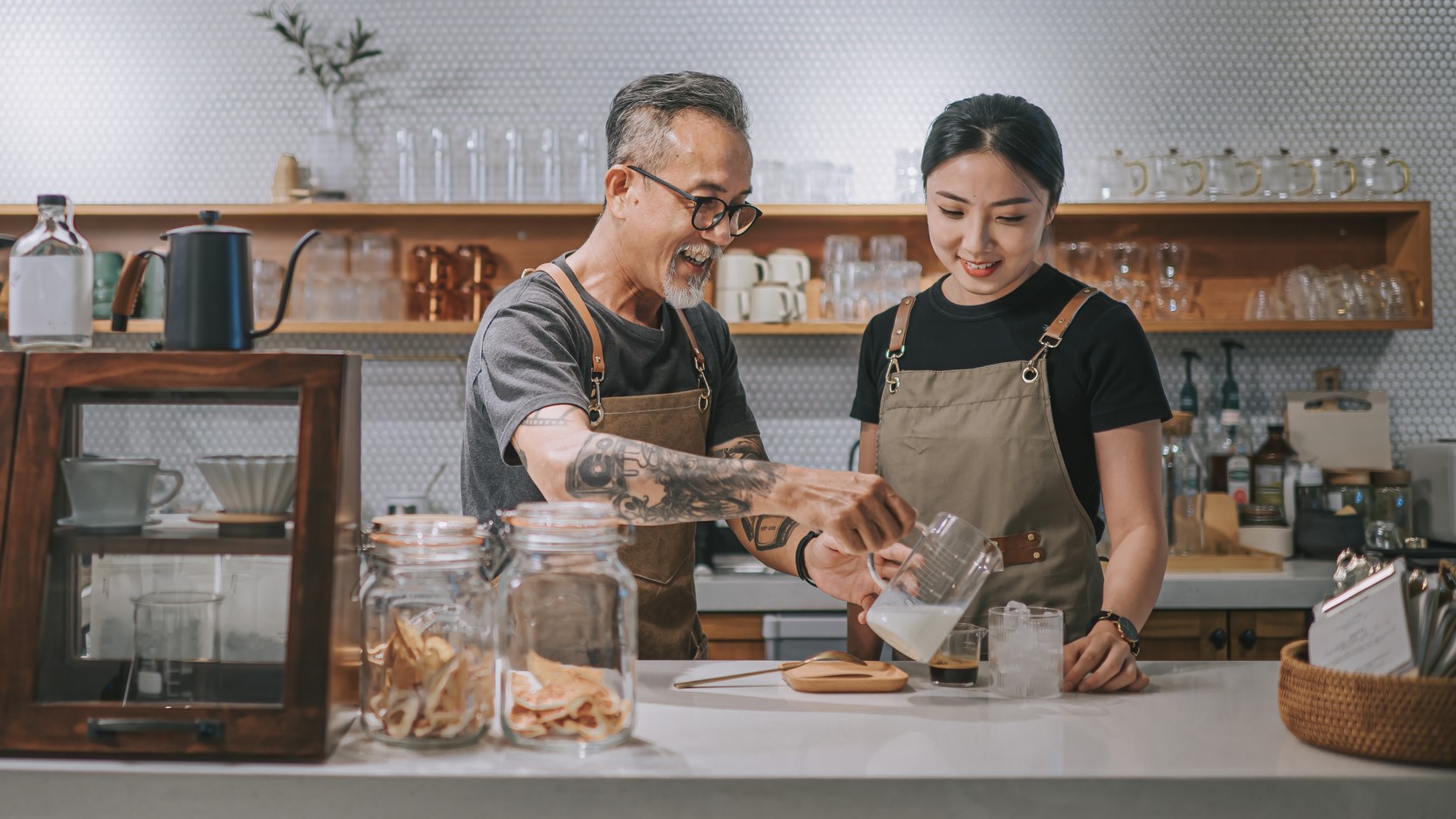 Barista instructing learner in cafe