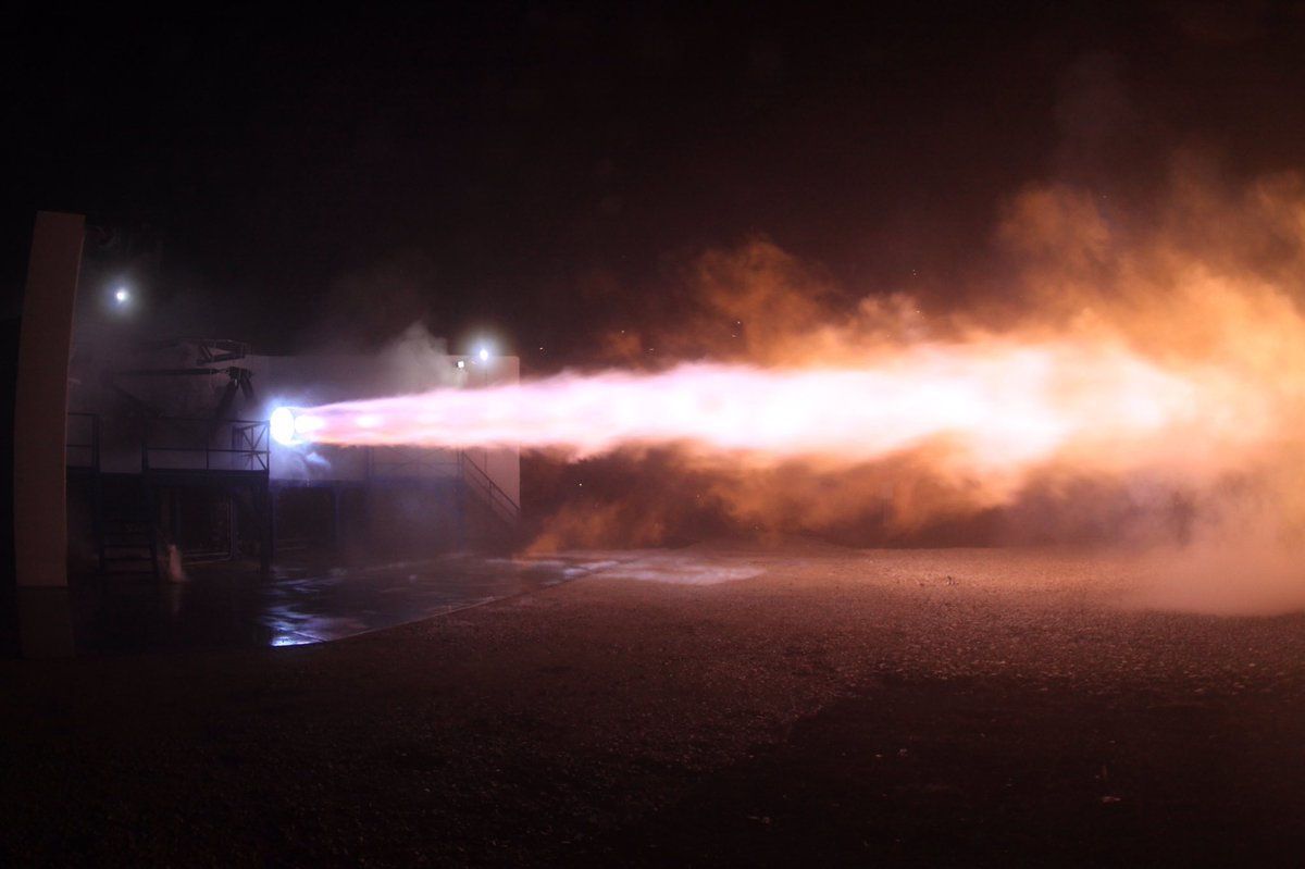 A large rocket engine blasts a jet of fire horizontally.