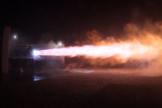 A large rocket engine blasts a jet of fire horizontally.