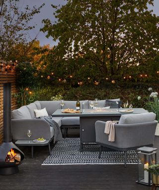 outdoor living with rug, fire pit and lights