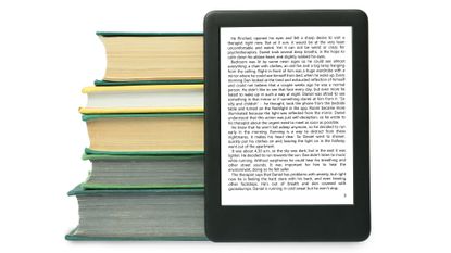 Kindle next to stack of books