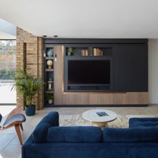 living room den with sofa and a large tv in an open plan space
