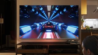 TCL C635 with fast-moving video game on it, in a living room