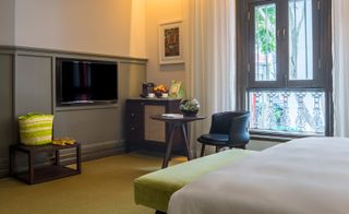 Hotel room view with small side table, chair and TV