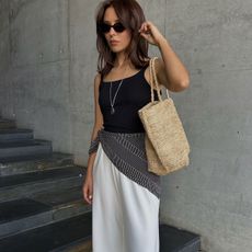 Woman in black tank top and white pants