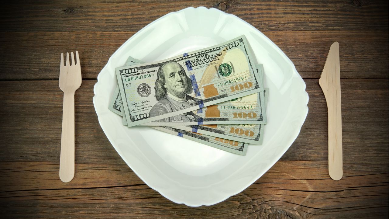 Hundred-dollar bills fanned out on a plate.