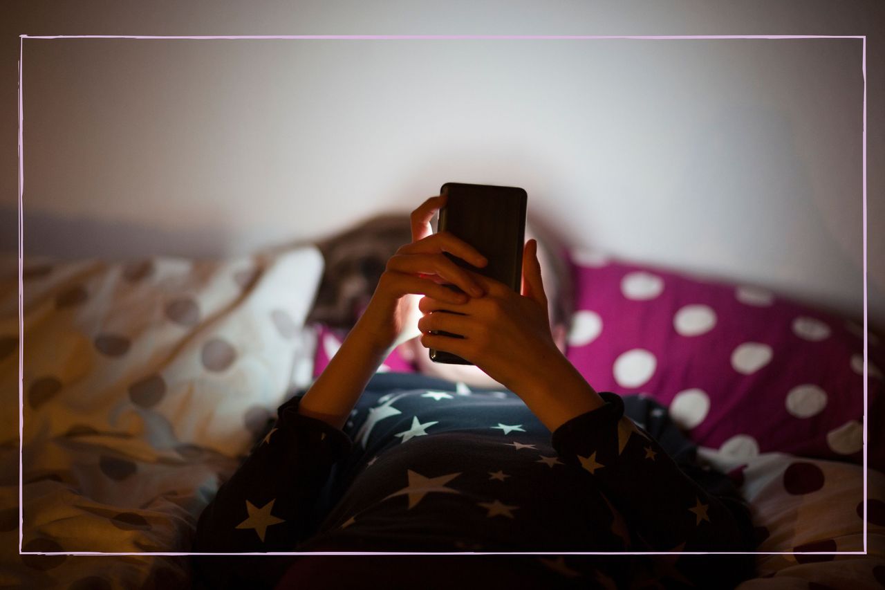 A girl on her phone while lying in bed