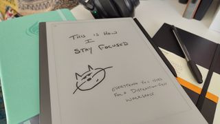 A reMarkable 2, Clever Fox planner, Moleskine notebook, and a PaperMate InkJoy on a desk in a home office