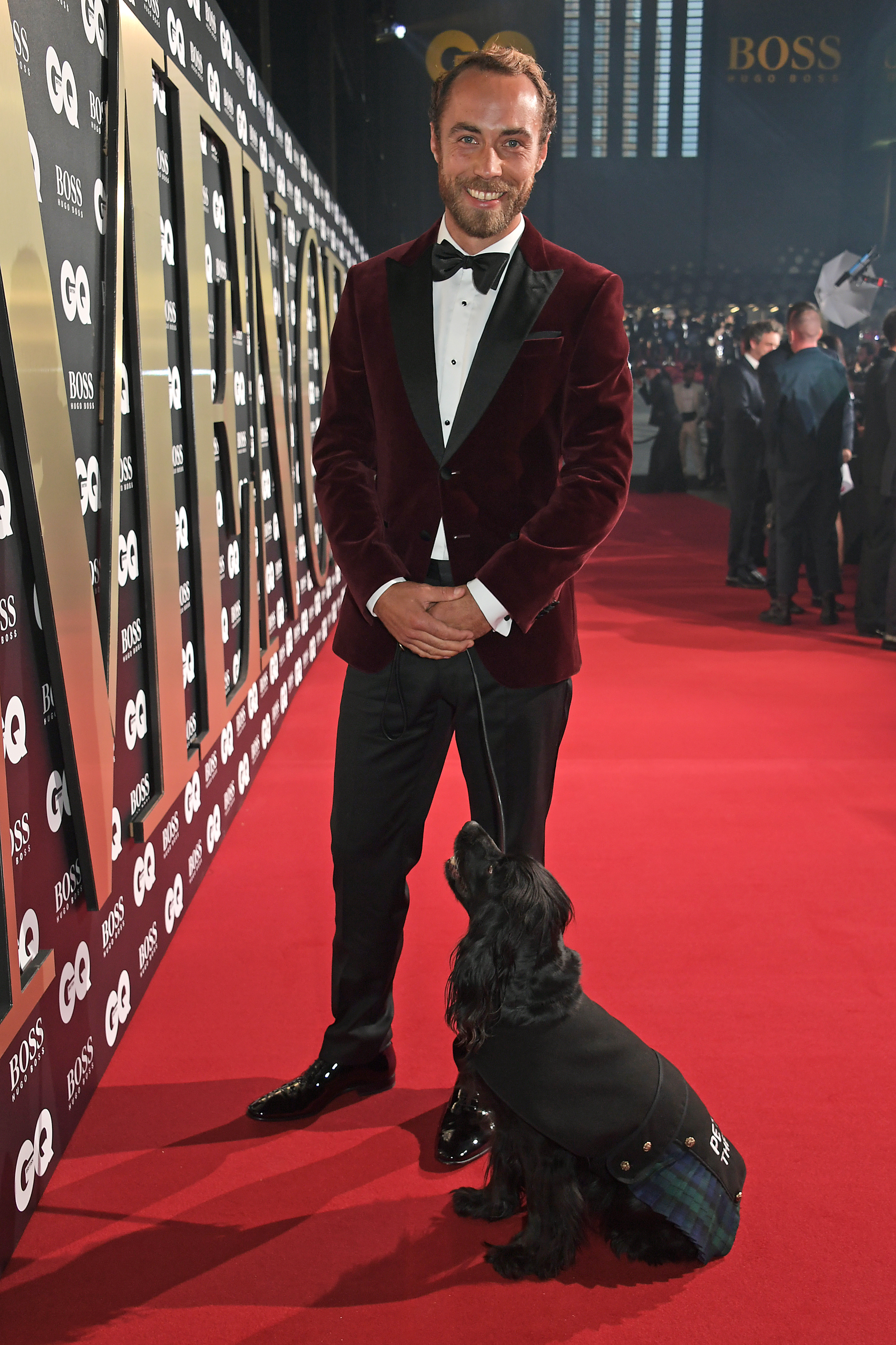 James Middleton wearing a tuxedo and holding his dog, Ella's leash, on the red carpet