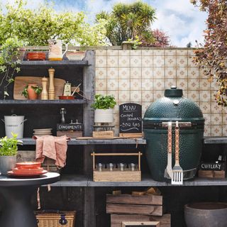 A barbecue situated against a tiled wall in a garden