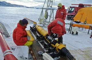 Researchers prepare Icefin for going under the ice. The machine uses foam (epoxy-filled glass balls) to float at the correct depth.