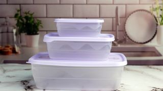 Three stacked plastic food containers on countertop