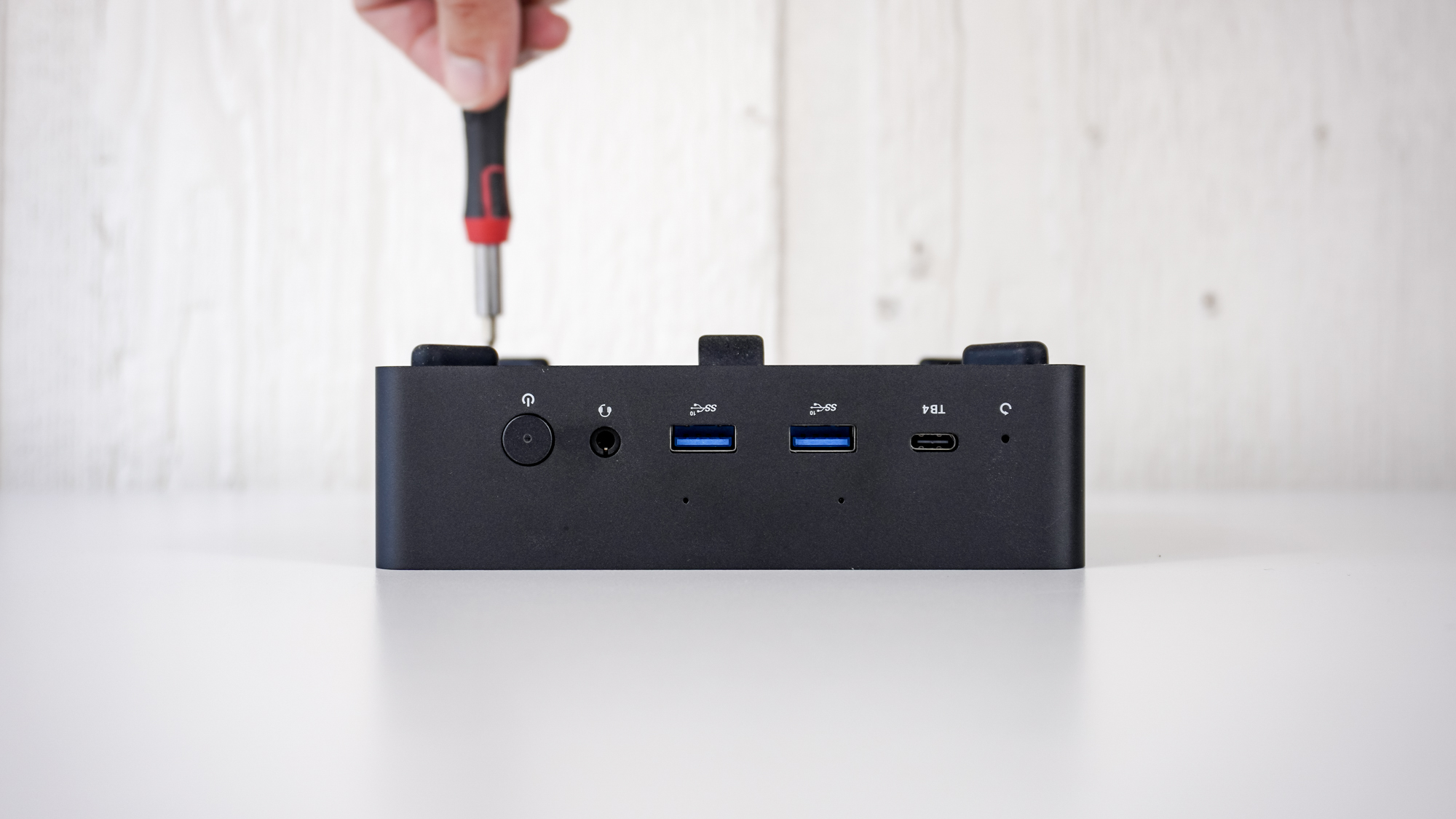 A person using a screwdriver to open the Minix Elite EU715-AI