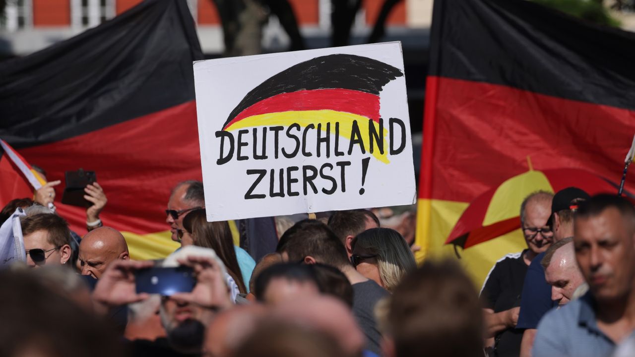 AfD supporters hold a placard that reads &#039;Germany First!&#039; at a campaign rally in Erfurt