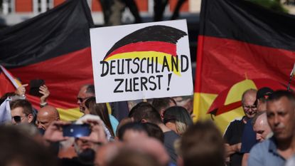 AfD supporters hold a placard that reads &#039;Germany First!&#039; at a campaign rally in Erfurt