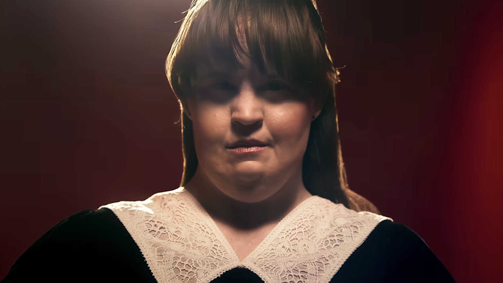 Jamie Brewer in black outfit with lace collar from Coven in American Horror Story 13 promo