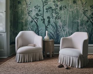 green bobatical wallpaper in a room with two chairs upholstered in a pale neutral fabric