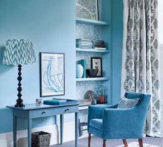 Living room with blue walls, desk, chair and lampshade