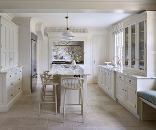 White kitchen with marble countertops and island