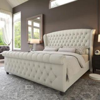 Dulane Upholstered Sleigh Bed against a brown wall.